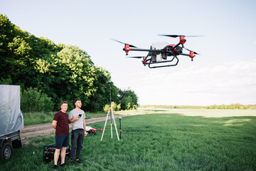 Modern drone flying over wheat grain field on sunny day. Agriculture industry