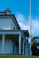 white historic house with blue sky and clouds in the background
