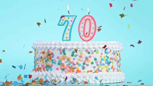 Birthday Cake With Burning Colorful Candles with Number 70 on Pastel Background. Falling confetti. Super Slow Motion, 1000 FPS.