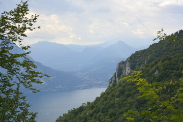 Panorama of mountain lake Como surrounded by green hills covered with cedar forest