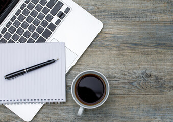 Obraz na płótnie Canvas Top view photo of laptop notebook computer and coffee cup on wooden background and copyspace. Business working space concept