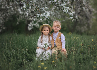 boy and girl stand in the apple orchard. boy sitting with girl. Love story