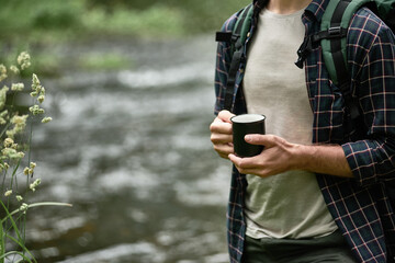 Hands of male tourist in a plaid shirt