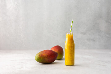 Ripe juicy mango and mango smoothies in a jar with a straw, copy space