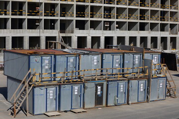 Metal cabins for workers in two floors on the construction of a concrete apartment building, Oktyabrskaya Embankment, St. Petersburg, Russia, May 2021