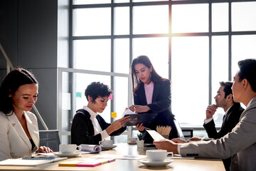 Achievement successful young beautiful businesswoman sharing experience success and giving presentation at conference meeting desk, five business people having discussion about project work in office 