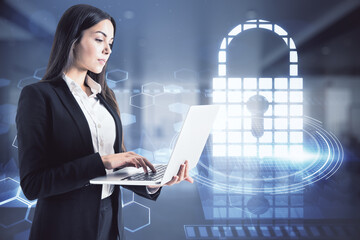 Attractive young woman using laptop with digital padlock screen on blurry office interior...
