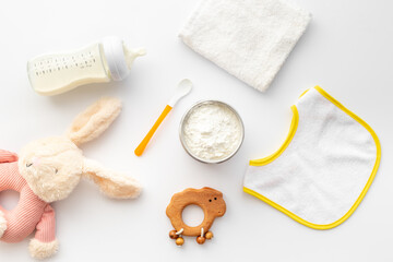 Baby milk in bottle with toy and powdered milk