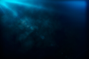 Blurry smoke and blue color ray of light from the top on blank dark background. Mockup
