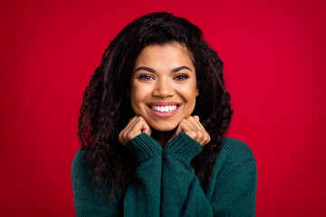 Photo of charming nice happy dark skin lady hold hands face fists smile isolated on red color background