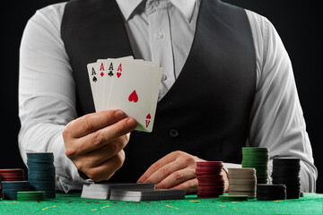 Male croupier in the casino at the table hands close-up. Casino concept, gambling, poker, chips on...