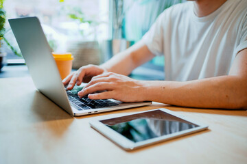 the programmer works in a cafe on a laptop. Remote work manager in a restaurant with a computer. Modern device order online on the website.