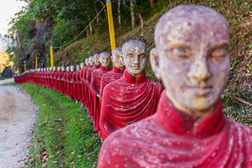 Row of monk statues at Kaw Ka Taung cave temple near Hpa An, Myanmar