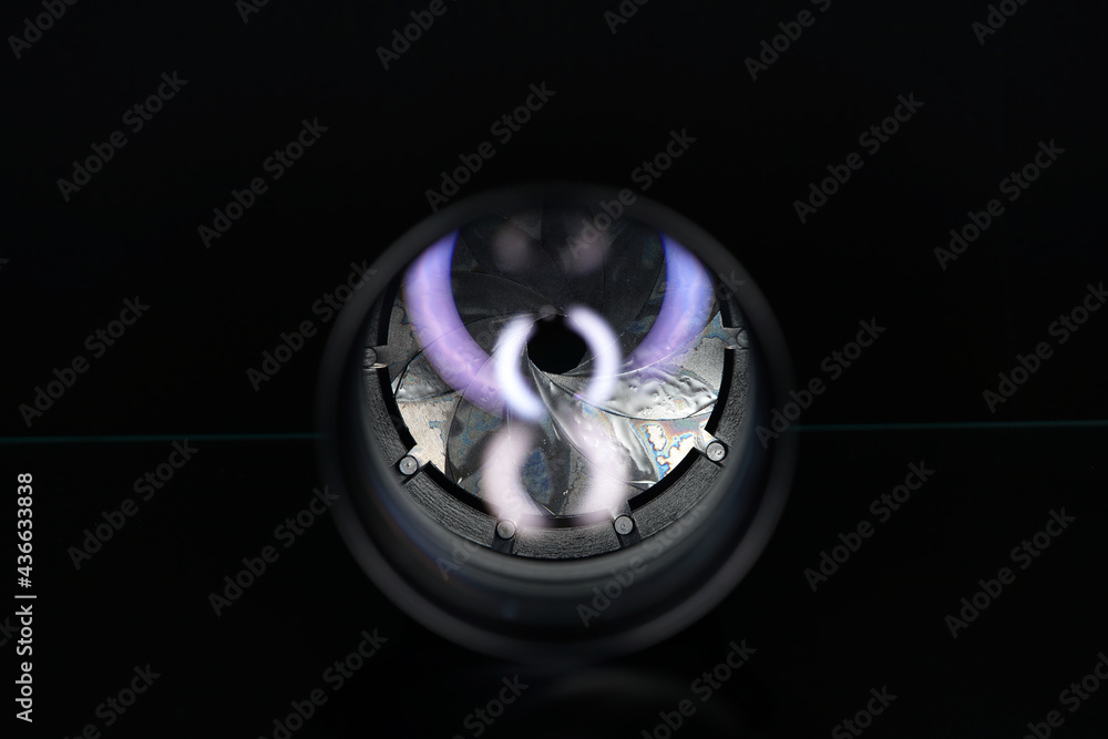 Poster Optical lens of a camera with a dim glowing number 8 in front of it in a dark environment
