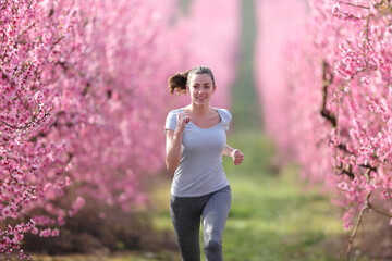 Front view of a runner running in a pink field