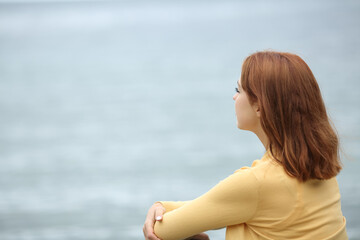 Woman contemplating ocean on the beach
