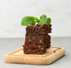 stack of square baked brownie chocolate pie pieces on wooden board