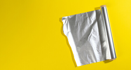 roll of twisted food foil for packaging food on yellow background