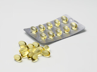 fish oil in capsules and blister pack on white background, food supplement for health