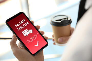 Man tracking parcel via smartphone indoors, closeup