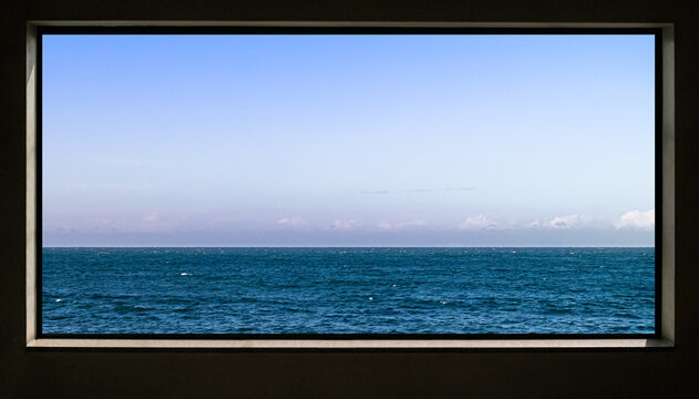 Fototapeta The horizon and wide sea seen from large indoor window.