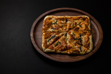 High angle shot of yummy pizza on a black surface.