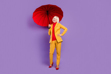 Full body photo of cheerful short hairdo elder lady hold umbrella wear yellow costume isolated on...
