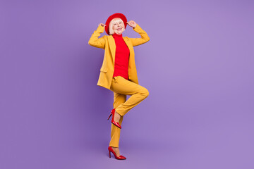 Full body profile photo of funky short hairdo mature lady stand wear yellow suit cap isolated on...