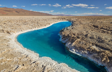 The salt flat Salar Pocitos with a small salt lake on the high altitude plateau of the puna in northwest Argentina