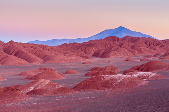 Desolate desert landscape with strongly eroded badlands in the vicinity of Tolar Grande on the high altitude plateau of the puna in northwest Argentina in the blue hour before sunrise