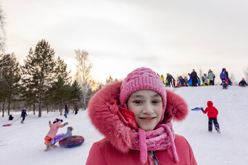 Girl with frost on the eyelashes on the background of playing children in the coldest in the world northern residential village Oymyakon.