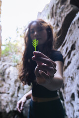 Yogi in nature cave holding a delicate leaf - close up