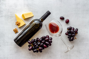 Red wine bottle with glass of wine and grape. Top view