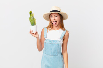 pretty woman with cheerful and rebellious attitude, joking and sticking tongue out and holding a...