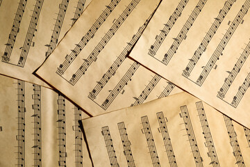 Many old note sheets as background, top view