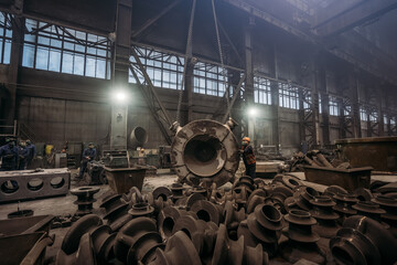Large cast iron product moved on girder crane in workshop of metallurgical plant. Foundry, Heavy...