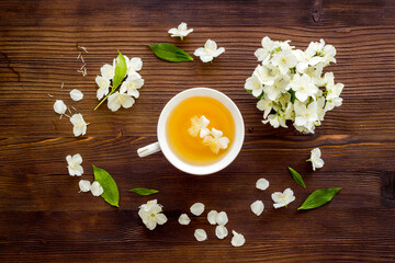 Cup of jasmine herbal tea with white flowers. Top view