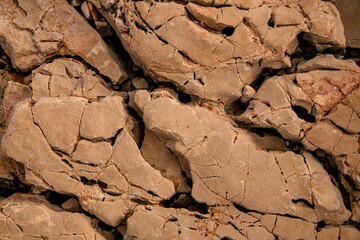 top view of brown stone coastline surface with cracks and erosion textures