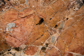 Close-up of bright colorful natural stone with cracks on the surface.