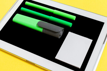 educational stationary lying on the screen of a tablet pc