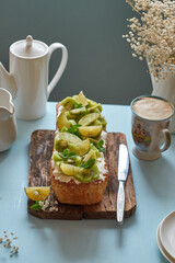 Citrus bread garnished with kiwi and lime. Blue background, side view.