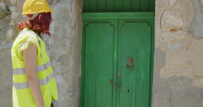 Soccorritore donna lascia un fiore in memoria delle vittime del sisma in una porta di una citt&agrave;
