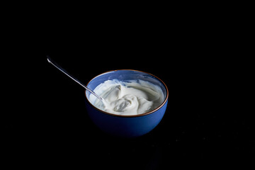 bowl filled with yogurt on a black background