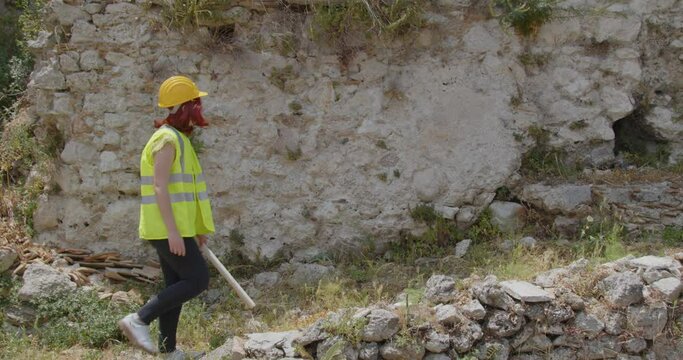 Giovane ragazza ingegnere con caschetto giallo visita la citt&agrave; distrutta dalla guerra in Ucraina