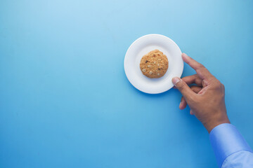 hand pick cookies from a plate , top view 