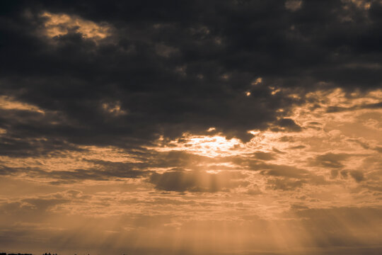 Thunderclouds with rays of the sun early in the morning in summer.