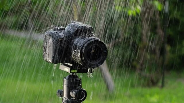 A digital camera on a tripod in the rain