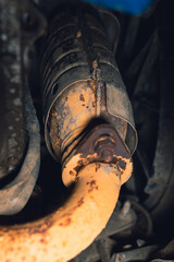 Vehicle underbody exhaust pipe, catalyst, resonator, exhaust system. Old parts require repair and replacement. Car service and maintenance. Standards and technical condition. selective focus - obrazy, fototapety, plakaty