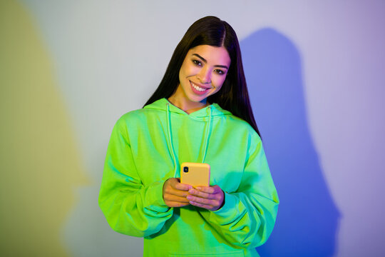 Photo of pretty adorable young lady wear green sweatshirt writing modern device isolated gradient color background
