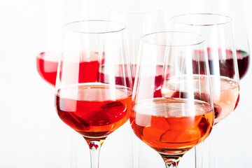 Rose wine glasses set on wine tasting. Different varieties, colors and shades of pink wines on white background